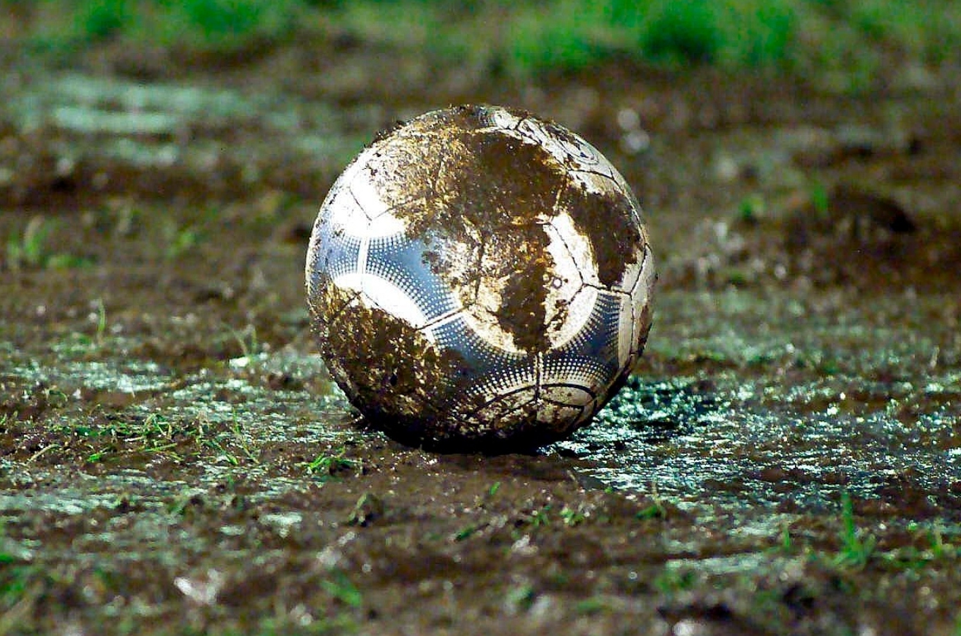 Pelota de fútbol embarrada.