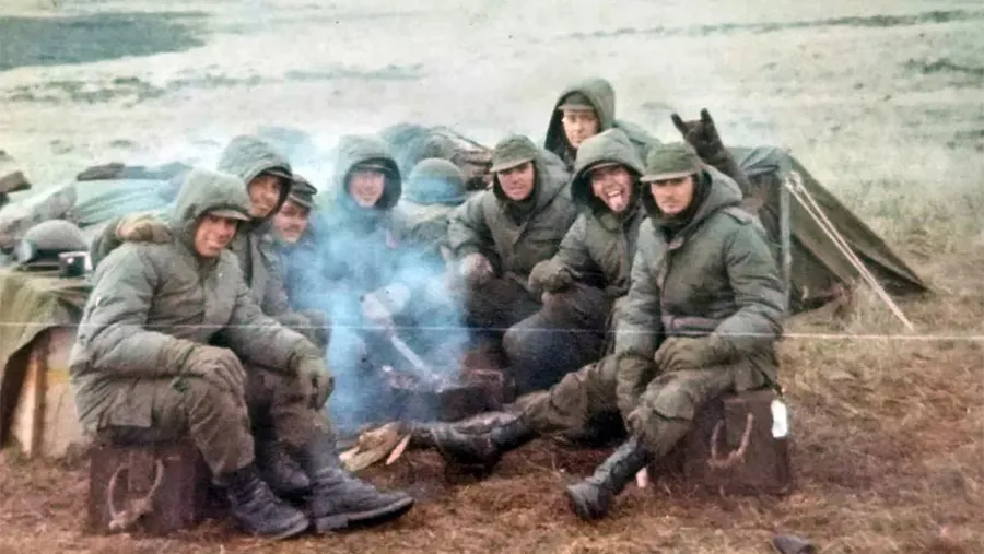 Julio Gluzman (primero de la derecha, el que está sentado en caja de municiones); en el cerro Dos Hermanas junto sus compañeros del Regimiento de Infantería 7. Archivo Hernán Dobry.