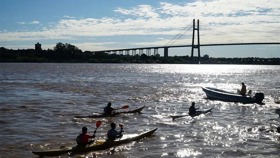 Un grupo de kayakistas navega cerca del puente Nuestra Señora del Rosario, que une las provincias de Santa Fe y Entre Ríos.