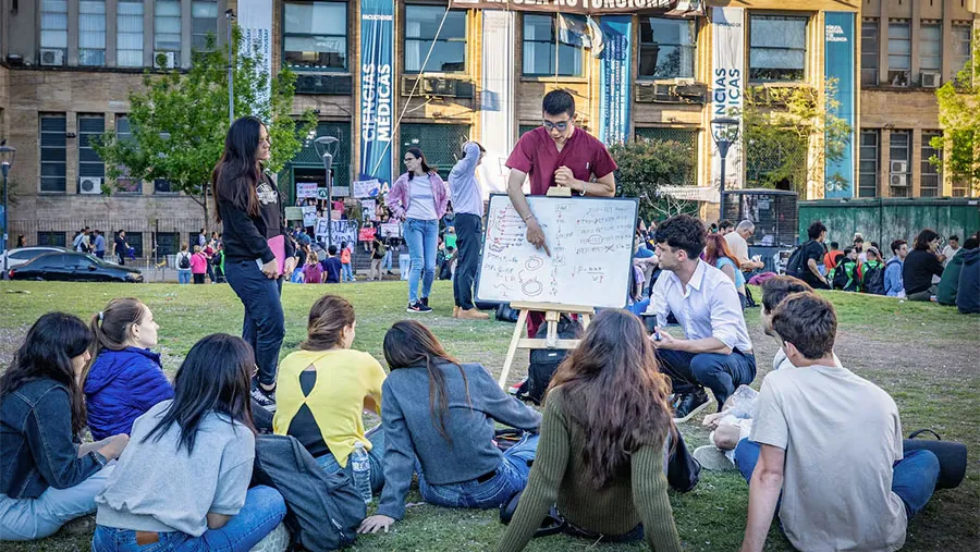 Un auxiliar de Anatomía imparte clases afuera de la Facultad de Medicina a un grupo de estudiantes como forma de protesta, en Buenos Aires. Un auxiliar de Anatomía imparte clases afuera de la Facultad de Medicina a un grupo de estudiantes como forma de protesta, en Buenos Aires.