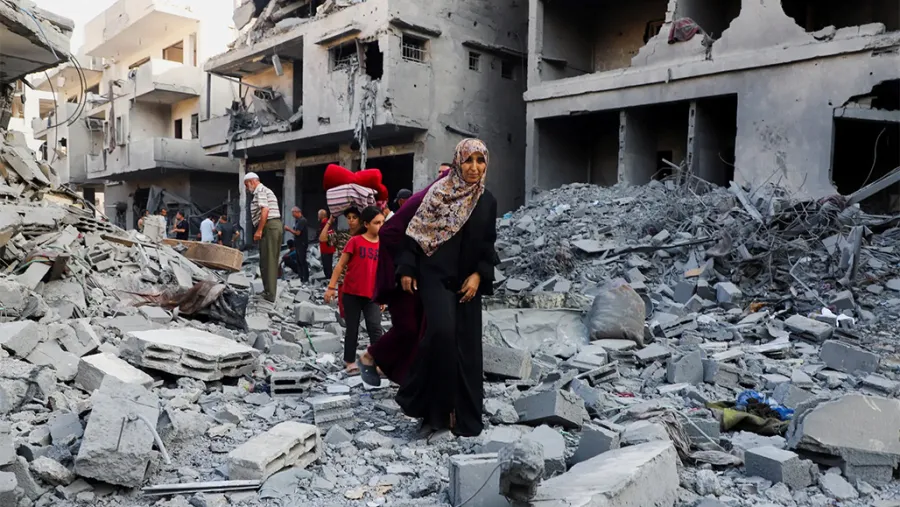 Personas caminando entre los escombros. Ciudad de Gaza el martes, tras una noche de ataques israelíes.