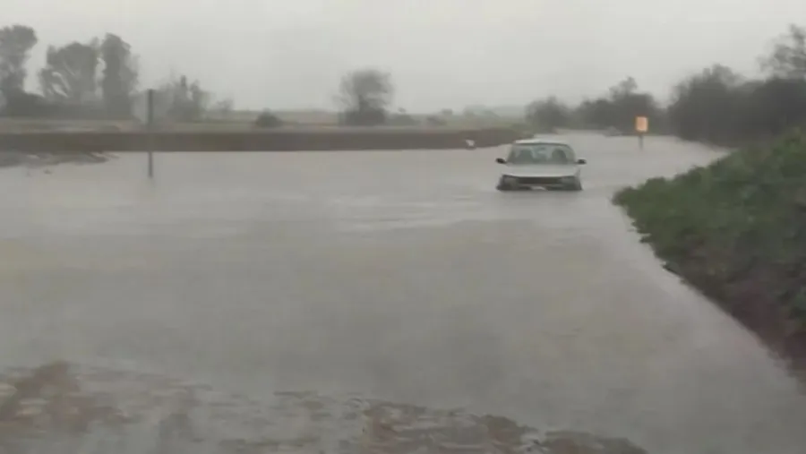 auto varado camino inundado