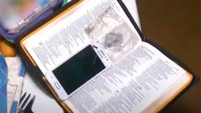 Un celular dentro de una Biblia.