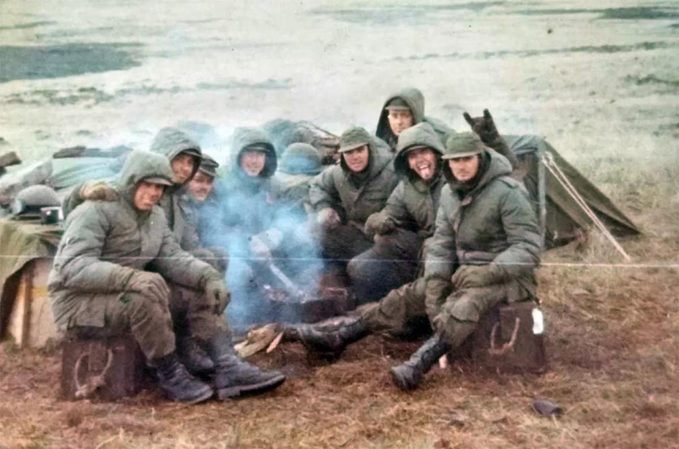 Julio Gluzman (primero de la derecha, el que está sentado en caja de municiones); en el cerro Dos Hermanas junto sus compañeros del Regimiento de Infantería 7. Archivo Hernán Dobry.