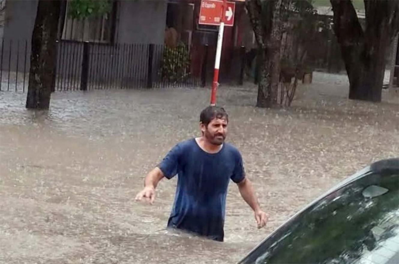 Un vecino intenta cruzar la Plaza Moreno de Villa Elisa.