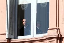 Martín Guzmán se asoma desde una ventana de la Casa Rosada, al lado está Alberto Fernández, antes del anuncio por el cambio en Ganancias.