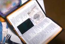 Un celular dentro de una Biblia.
